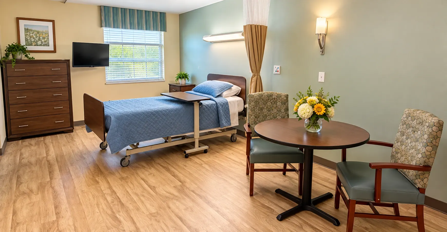 A resident room at Vivo Healthcare Gandy, with a bed, dresser and a small table by the window